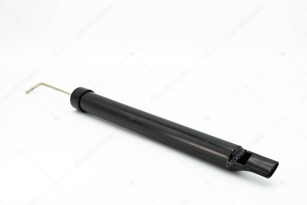 Black slide whistle lying on a white background