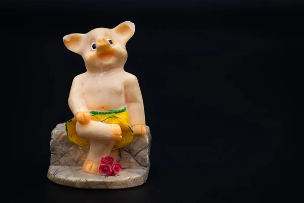 Beeldje van een kleine piggy zittend op een bankje — Stockfoto
