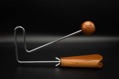 Bir vibraslap gümüşü, siyah yeraltı üzerinde kahverengi ahşap