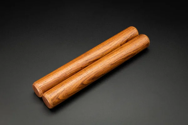 A pair of wooden claves lying on a black underground — 스톡 사진