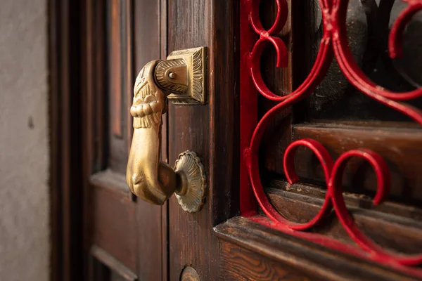 Una manija de la puerta de bronce en una puerta marrón en Venecia —  Fotos de Stock