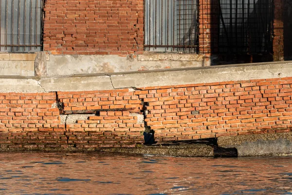 Un muro di mattoni rotti in acqua a Murano — Foto Stock