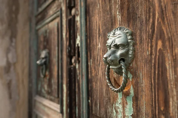 Una manija de puerta de bronce en una puerta de madera en Venecia —  Fotos de Stock