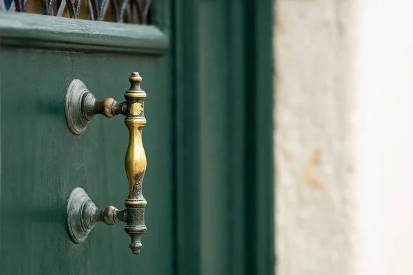 A bronze door handle on a green door in Venice — Stok fotoğraf