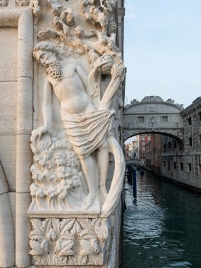 Venedik 'teki (İtalya) Doge Sarayı' ndaki bir adamın rahatlaması, arka planda Ponte dei Sospiri