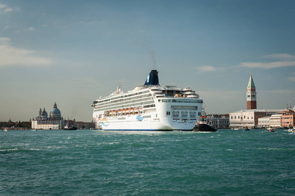Венеция / Италия 11 04 2016: Круизное судно проходит через Венецию (Италия), дворец дожей и кампанилу в солнечный день осенью
