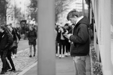 Vienna, Austria - 11/29/2019: Young man looking at his smartphone during Earth-strike demonstration