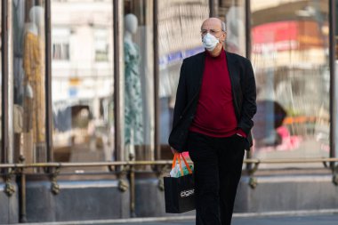 Viyana, Avusturya - 04 Nisan 2020: Sokaklarda maske takan adam, Corona virüsü enfeksiyonuna karşı koruma, ilkbaharda güneşli bir gün