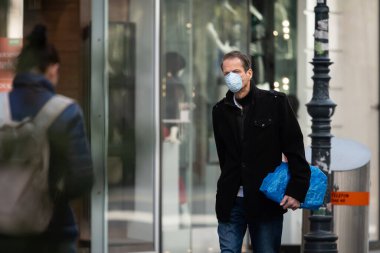 Viyana, Avusturya - 04 Nisan 2020: Sokaklarda maske takan adam, Corona virüsü enfeksiyonuna karşı koruma, ilkbaharda güneşli bir gün