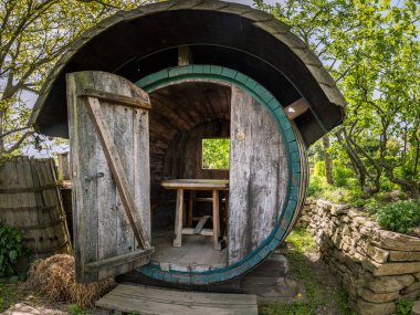 Yazın güneşli bir günde içinde masa ve bank olan büyük bir şarap fıçısı.