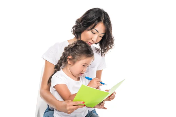 Mutter und Tochter schreiben in Textbuch — Stockfoto