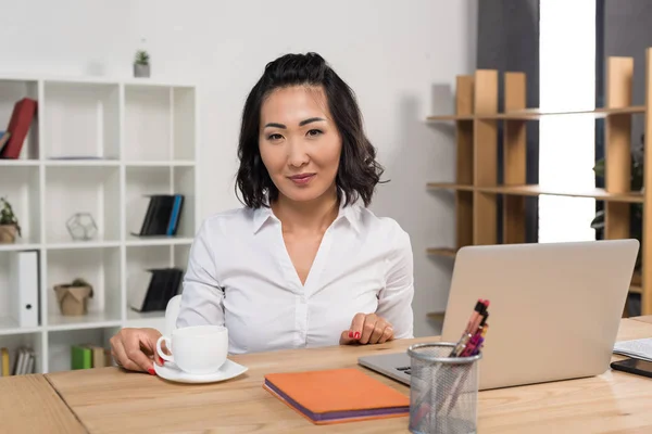 Zakenvrouw met laptop en koffie — Stockfoto