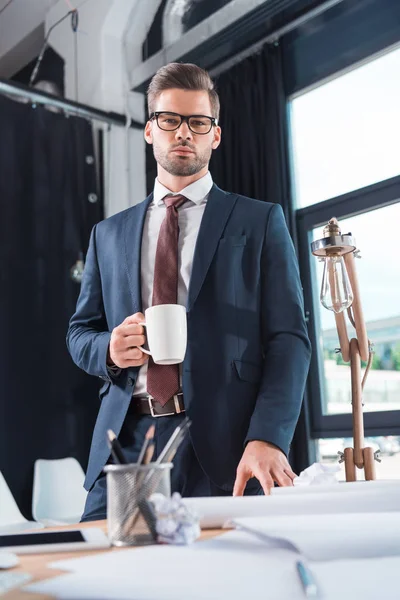 Businessman drinking coffee in office — Stock Photo, Image
