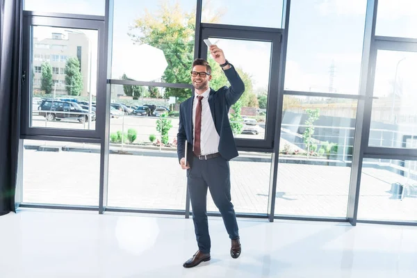 Businessman holding laptop in office — Free Stock Photo