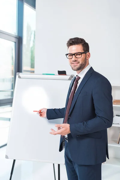 Homme d'affaires pointant vers le tableau blanc — Photo gratuite