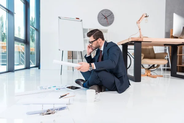 Businessman working with papers and devices — Free Stock Photo