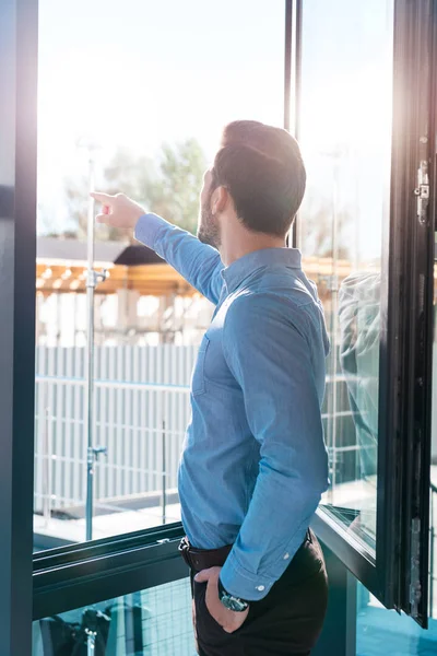 Homme d'affaires pointant vers la fenêtre — Photo