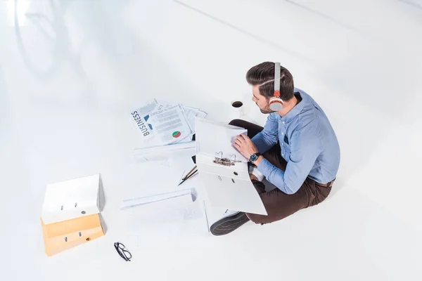 Businessman in headphones working with papers — Stock Photo, Image