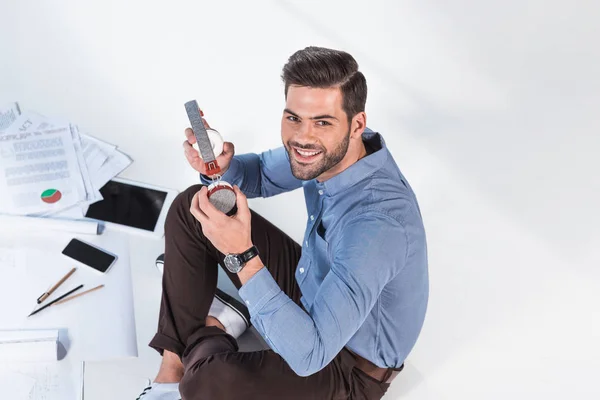 Businessman with headphones working with papers — Free Stock Photo