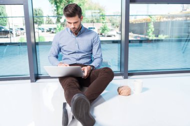 Ofiste dizüstü bilgisayar kullanan bir iş adamı