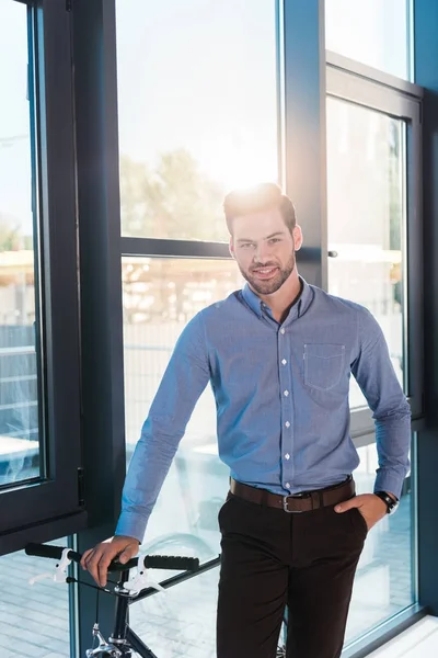 Businessman with bicycle in office — Free Stock Photo