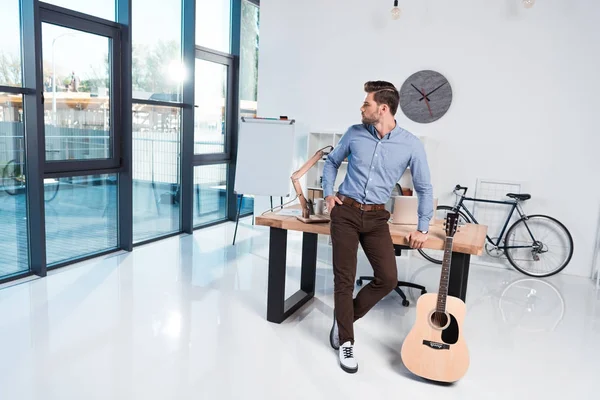 Affärsman med gitarr i office — Stockfoto