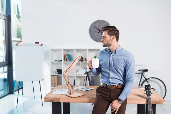 Affärsman med kaffe på kontoret — Stockfoto