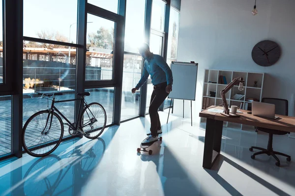 Affärsman på skateboard i office — Stockfoto