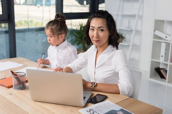 Asiática empresária com filha no escritório — Fotografia de Stock