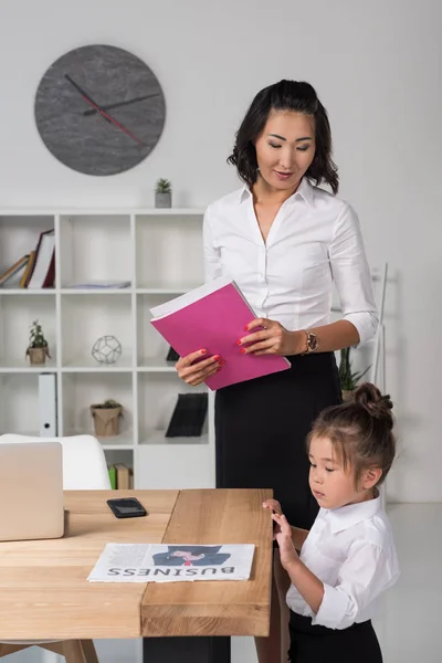 Asiático mujer de negocios con hija en oficina — Stock Photo