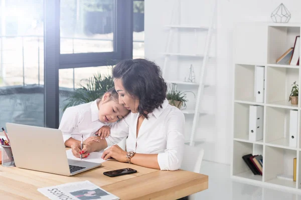 Asian businesswoman with daughter in office — Stock Photo