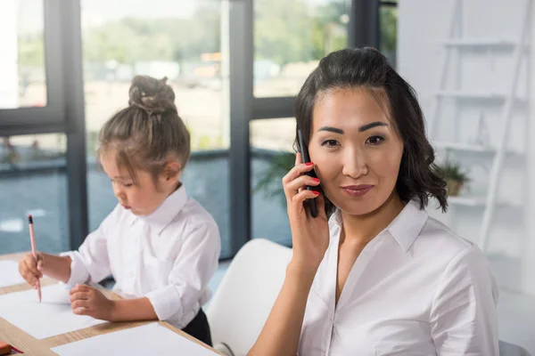 Азіатська бізнес-леді з дочкою в офісі — стокове фото