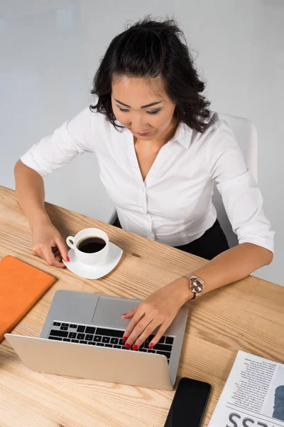 Femme d'affaires avec ordinateur portable et café — Photo de stock