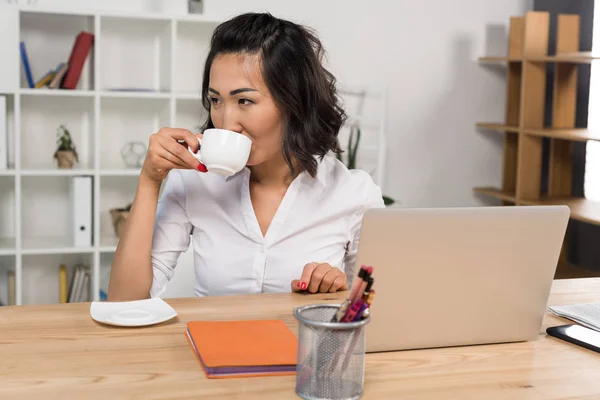 Femme d'affaires avec ordinateur portable et café — Photo de stock