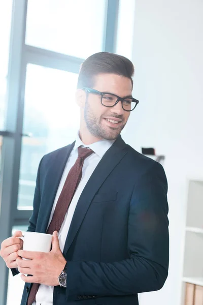 Businessman drinking coffee in office — Stock Photo