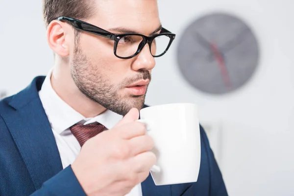 Бизнесмен пьет кофе в офисе — стоковое фото