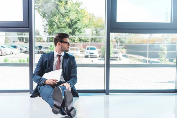 Empresario sosteniendo portátil en la oficina - foto de stock