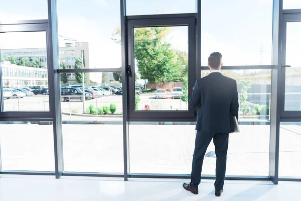 Businessman holding laptop in office — Stock Photo