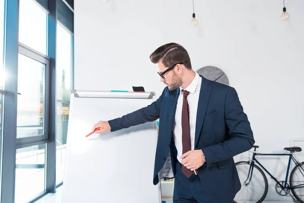 Geschäftsmann zeigt auf Whiteboard — Stockfoto