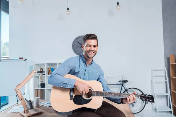 Hombre de negocios con guitarra en la oficina - foto de stock