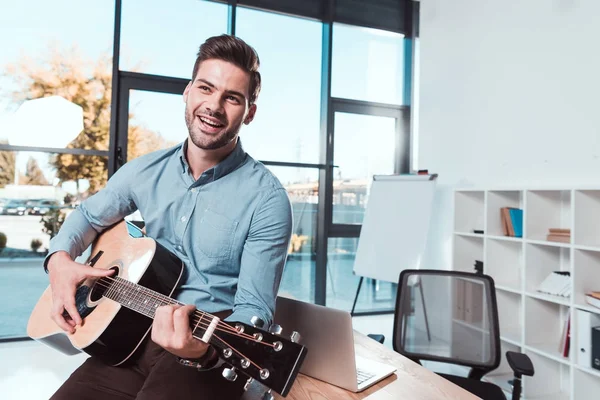 Hombre de negocios con guitarra en la oficina - foto de stock