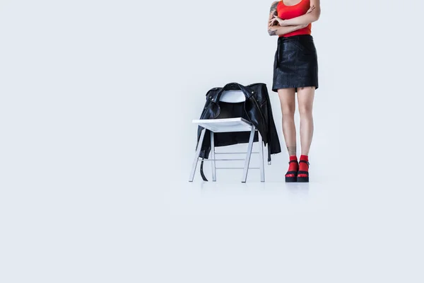 Fashionable girl standing at chair — Stock Photo, Image