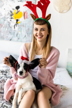 baş ve santa şapka içinde köpek yavrusu üzerinde geyik ile gülümseyen kadın portresi boynuzları 