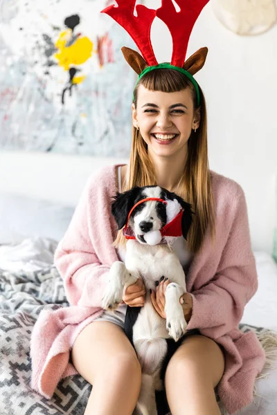 baş ve santa şapka içinde köpek yavrusu üzerinde geyik ile gülümseyen kadın portresi boynuzları 