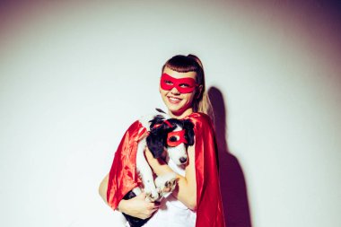 kadın holding köpek süper kahraman kostümü içinde gülümseyen portresi