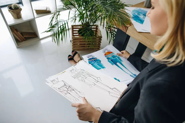 Fashion designer holding sketches — Stock Photo