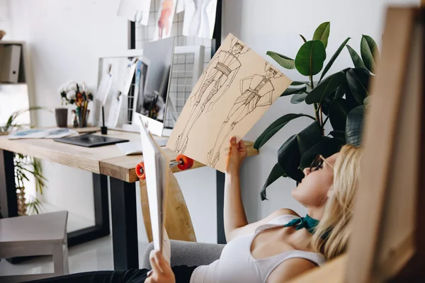 Young fashion designer with sketches — Stock Photo