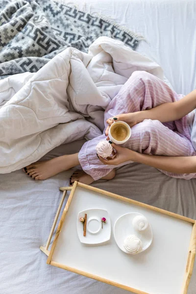 Vista aérea da mulher com xícara de café e zephyr em mãos descansando na cama — Fotografia de Stock
