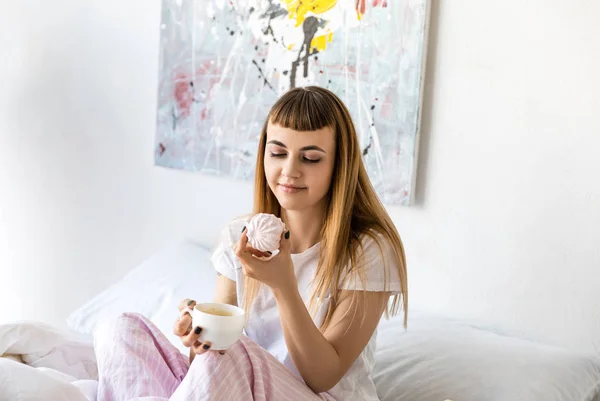 Retrato de jovem com xícara de café e zephyr de manhã em casa — Fotografia de Stock