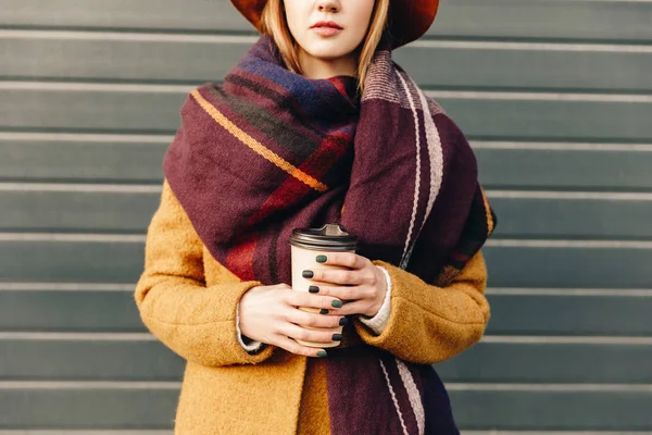 Partial view of woman in autumn jacket and hat with coffee to go in hands — Stock Photo